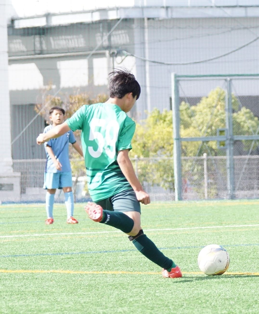 サッカーボールを蹴っている少年